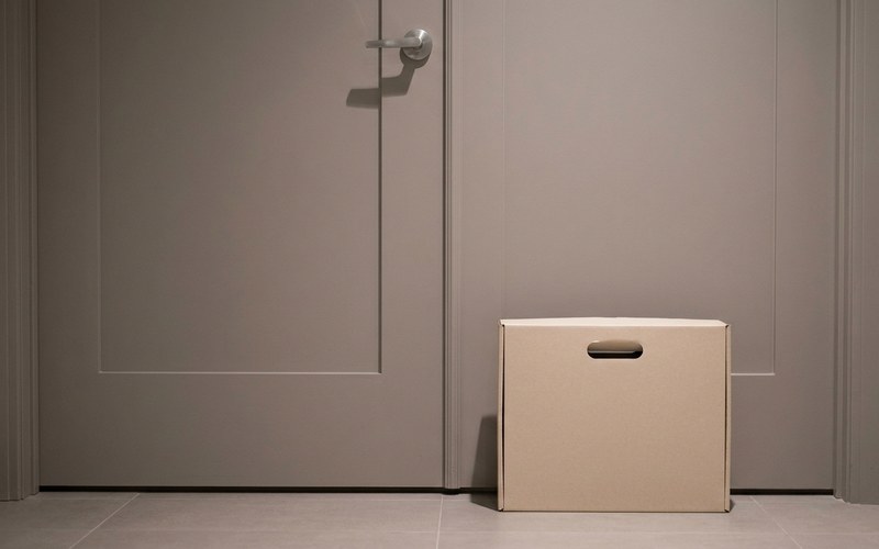 A delivery box left outside a condominium unit door in a BGC or Taguig high-rise hallway.