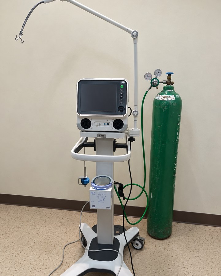 Amoul T6 ventilator on its stand beside an oxygen cylinder.