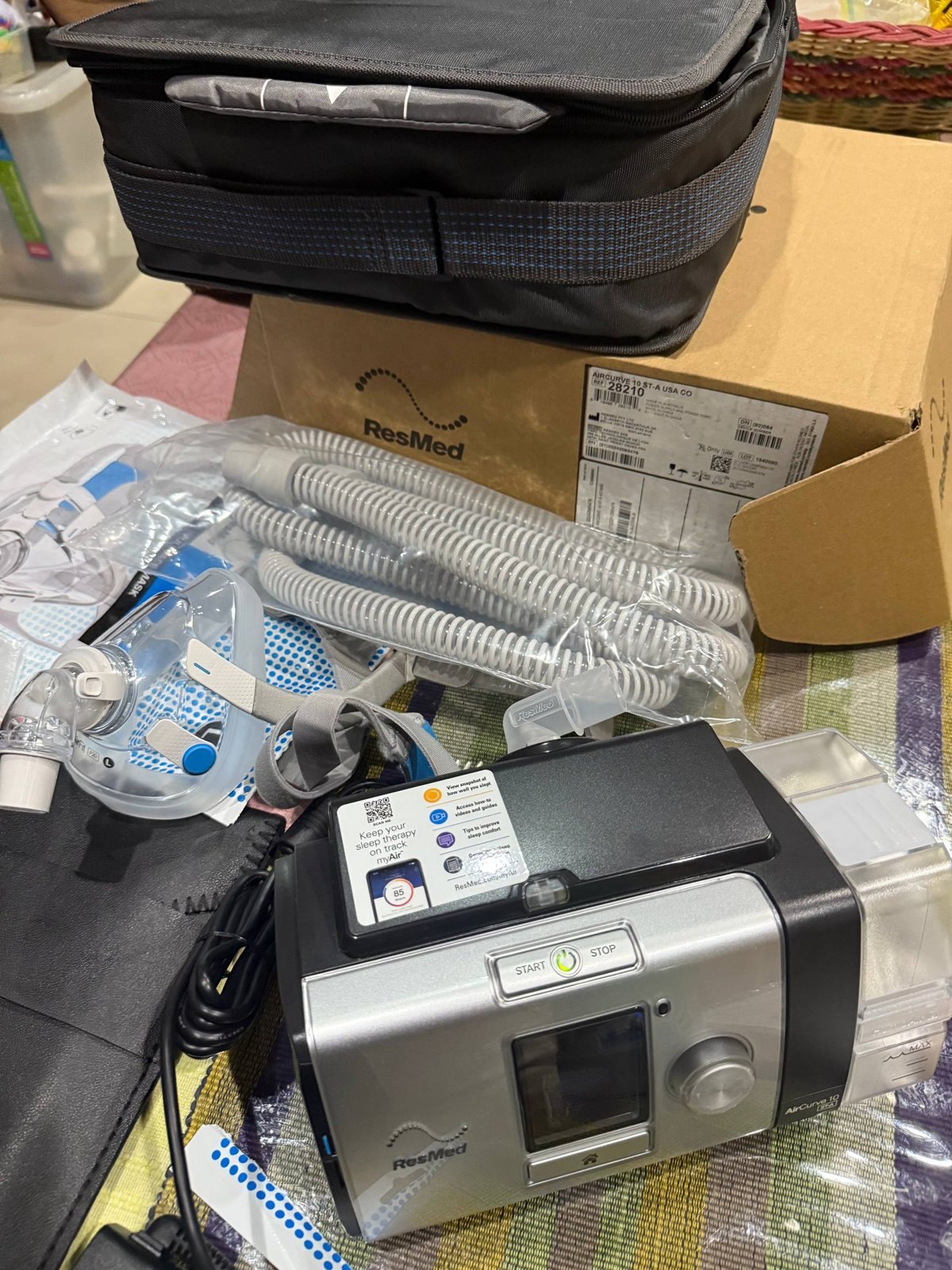 The ResMed machine, tubing and mask laid out on a table at setup